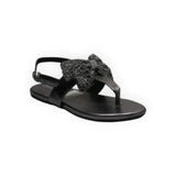 ARQS.PK black flat thong sandals featuring a decorative glittery bow detail and an adjustable ankle strap.