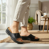 ARQS.PK Dr Mauch reflexology slippers in black with acupressure footbed worn indoors on a jute rug