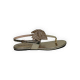 ARQS.PK gold metallic thong sandals featuring a decorative textured bow and adjustable ankle strap
