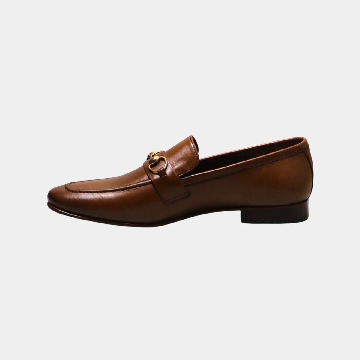 ARQS.PK tan leather loafers featuring a gold-tone horsebit detail on the vamp in a classic slip-on silhouette.